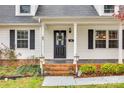 Inviting front porch featuring black door with wreath, brick steps, and manicured landscaping at 110 Yorktowne St, Fort Mill, SC 29715