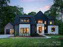 Modern home boasts a black and stone exterior with meticulous landscaping, perfect for evening enjoyment at 116 Hunt Camp Trl # 11, Davidson, NC 28036