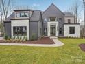 Contemporary home featuring a unique architectural design, stone accents, dark siding and a well-maintained front lawn at 116 Hunt Camp Trl # 11, Davidson, NC 28036