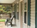 Inviting porch with comfortable chairs, a swing and green shutters, perfect for relaxing and enjoying the outdoors at 369 Pinecrest Cir, Troy, NC 27371