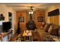 Inviting living room with rustic decor, featuring a wood-burning stove, comfortable seating and wood accents at 369 Pinecrest Cir, Troy, NC 27371
