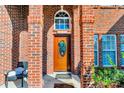 Welcoming front porch with brick columns and a stained glass door at 98 Poplar Woods Dr, Concord, NC 28027