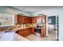 Spacious kitchen with wood cabinets, stainless steel appliances, and tile countertops at 98 Poplar Woods Dr, Concord, NC 28027