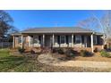 Charming single-story home with a covered front porch, updated shutters, and manicured landscaping at 1308 Princeton Ave, Gastonia, NC 28054