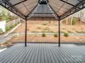 Covered patio with string lights overlooking wooded area at 2565 Meadow Crossing Dr, Dallas, NC 28034