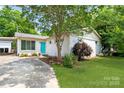 Charming one-story house features a vibrant turquoise door and well-manicured lawn at 549 Spring Sw St, Concord, NC 28025