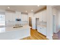 Modern kitchen with white cabinets, quartz countertops, and a large island at 9601 Pointer Rd # 77, Huntersville, NC 28078