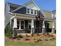 Stylish home with a covered porch featuring stone supports and manicured landscaping at 9605 Pointer Rd # 78, Huntersville, NC 28078