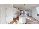 Modern white kitchen with large island, pendant lighting, and stainless appliances at 9605 Pointer Rd # 78, Huntersville, NC 28078