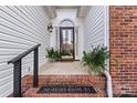 Inviting front porch with brick steps, black railings, and decorative plants at 10302 Sawtimber Ct, Huntersville, NC 28078