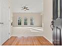 Bright living room featuring hardwood floors, a ceiling fan, and multiple windows at 10302 Sawtimber Ct, Huntersville, NC 28078