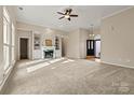 Spacious living room featuring neutral carpet, a fireplace, and built-in shelving at 10302 Sawtimber Ct, Huntersville, NC 28078