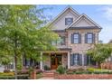 Two-story home with gray and brick exterior, dark shutters, and a manicured lawn at 1117 Churchill Commons Dr, Charlotte, NC 28211