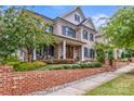 Two-story home with brick facade, landscaping, and a brick walkway at 1117 Churchill Commons Dr, Charlotte, NC 28211