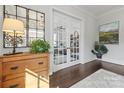 Bright foyer featuring dark hardwood floors, white trim, glass french doors, and decorative furnishings at 1117 Churchill Commons Dr, Charlotte, NC 28211