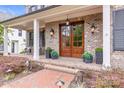 Brick front porch with double doors, lanterns, and seating area at 1117 Churchill Commons Dr, Charlotte, NC 28211