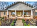 Inviting front porch with yellow doors, ample seating, and meticulous landscaping for a welcoming curb appeal at 1115 Stony Point Rd, Kings Mountain, NC 28086