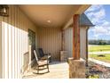 Inviting covered front porch with wooden pillars and comfortable rocking chairs at 174 Bellingshire Dr, Mt Ulla, NC 28125