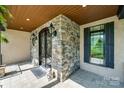 Inviting front porch with stone accents, decorative iron door, and tiled flooring at 546 Little Cove Ln, Lake Wylie, SC 29710