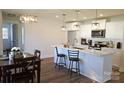 Open kitchen showcasing white cabinets, stainless appliances, island with bar seating, and view into the dining area at 625 Charles St, Rockwell, NC 28138