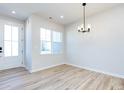 Well-lit dining area with wood floors, and a modern chandelier at 8912 Connover Hall Ave, Charlotte, NC 28215