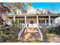 Front view of charming house with wrap-around porch and brick steps at 917 Patrick Johnston Ln, Davidson, NC 28036