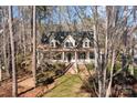 Charming two-story home with inviting front porch and brick stairs, surrounded by mature trees at 917 Patrick Johnston Ln, Davidson, NC 28036