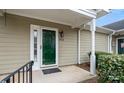 Close-up of a home's entryway featuring a covered porch with white pillars and an elegant green door at 2712 New Hamlin Way, Charlotte, NC 28210