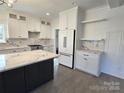 Modern kitchen features white cabinets, marble countertops, and a large island at 496 19Th Avenue Nw Cir, Hickory, NC 28601
