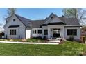 Charming modern farmhouse featuring white siding, black trim, and manicured lawn at 5056 Bridge Way, Denver, NC 28037
