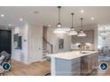 Modern open kitchen featuring an island with pendant lighting and stainless steel appliances, seamlessly connects to the living and dining areas at 14042 Aikenwood Dr, Charlotte, NC 28278