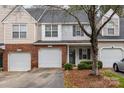 Tan and brick townhouse with a two-car garage and neat landscaping at 2022 University Heights Ln, Charlotte, NC 28213