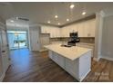 Modern white kitchen featuring a large island, stainless steel appliances, and hardwood floors at 5544 Stafford Rd # 30, Charlotte, NC 28215