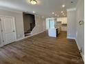 Open-concept living space with hardwood floors, stairs, and a glimpse of the modern kitchen at 5544 Stafford Rd # 30, Charlotte, NC 28215