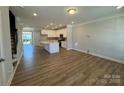 Bright, open-concept living space with hardwood floors, white kitchen, and a center island at 5544 Stafford Rd # 30, Charlotte, NC 28215