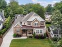 Beautiful aerial view of a brick home with an inviting front porch and lush landscaping at 3227 Pinehurst Pl, Charlotte, NC 28209