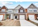Townhome exterior with brick and siding, 2-car garage, and front yard at 4153 Black Ct # 173, Harrisburg, NC 28075
