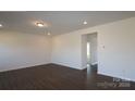 An open-concept living room featuring recessed lighting, base molding and dark wood flooring at 2608 Clipper Nw Ct, Concord, NC 28027