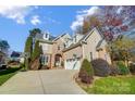 Beautiful two-story home featuring a stone and stucco facade, dormer windows, mature landscaping, and a curved driveway at 2315 Smith Harbour Dr, Denver, NC 28037