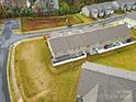 Aerial view of townhouses from the rear, showing patios and yards at 2471 Palmdale Walk Dr # 107, Fort Mill, SC 29708