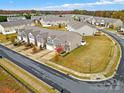 Aerial view of townhouses with a landscaped lawn and street at 2471 Palmdale Walk Dr # 107, Fort Mill, SC 29708