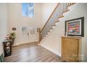 Inviting foyer featuring a soaring ceiling, wood-look floors, and a staircase with metal spindles at 10221 Hanging Moss Trl, Mint Hill, NC 28227