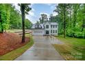 Beautiful two-story home with a two-car garage, a long driveway, and lush green landscaping at 10221 Hanging Moss Trl, Mint Hill, NC 28227