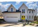 Charming home boasting a two-car garage and a vibrant yellow front door under a bright blue sky at 10221 Hanging Moss Trl, Mint Hill, NC 28227