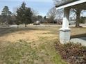 Home's front yard with a grass lawn, some trees, and a view of the street from the porch column at 105 Beaver St, China Grove, NC 28023