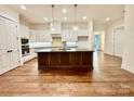 Modern kitchen with white cabinets, large island, and hardwood floors at 166 Fulworth Nw Dr # 67, Concord, NC 28027