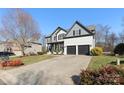 Two-story home with gray and white exterior, two-car garage, and landscaped yard at 1811 Robbins Meadows Dr, Waxhaw, NC 28173