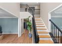 Elegant staircase with black railing and marble-look risers at 1811 Robbins Meadows Dr, Waxhaw, NC 28173