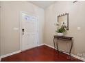 Entryway featuring a stylish mirror, modern door hardware, hardwood floors, and a crisp white front door at 7122 Abbotts Glen Dr, Charlotte, NC 28212