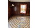 Living room featuring wood walls and damaged tile floor at 111 James Love School Rd, Shelby, NC 28152